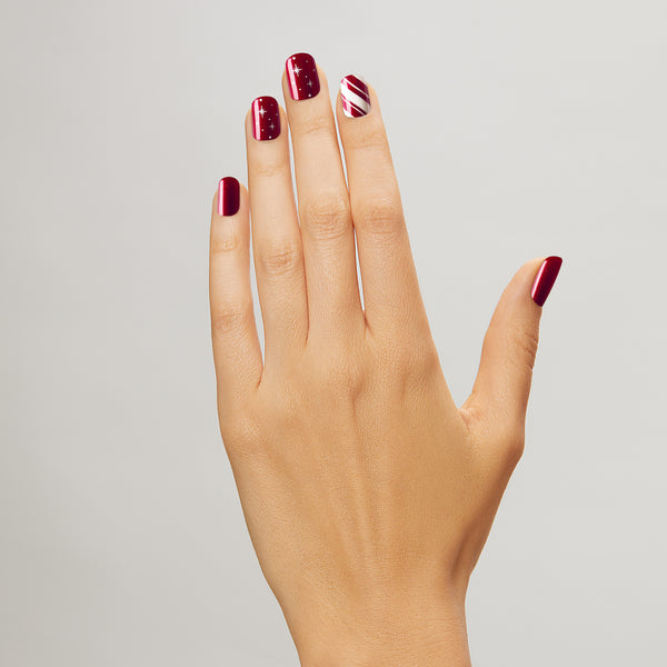 For the lover of all things sweet. Short length, square shape, glossy finish. Shimmery red press-on gel nails featuring stripes, red glitter, and starry accents.