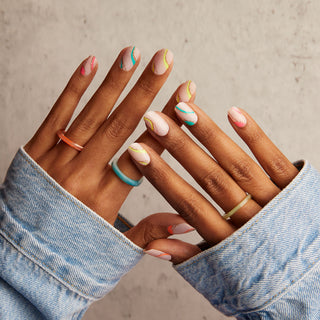 Sheer, nude pink gel nail strips featuring neon, multicolor swirls & gold glitter with mega volume and maximum shine.