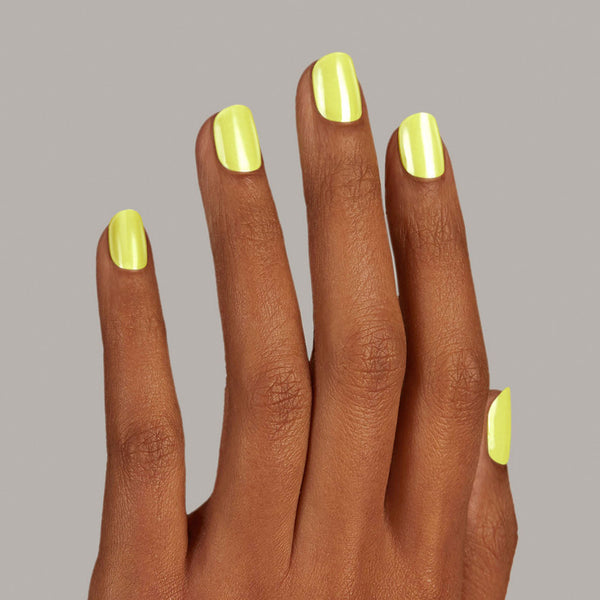 A hand with Lime green gel nail strips featuring a shimmery chrome finish