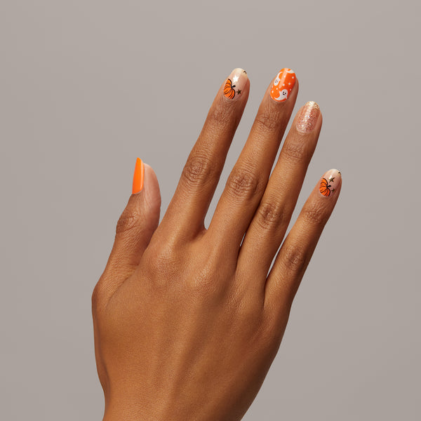 The prettiest pumpkin in the patch! Bright orange & sheer nude nail strips featuring pumpkin & ghost icons, iridescent glitter, and gold foil stars with a glossy, high-shine finish.