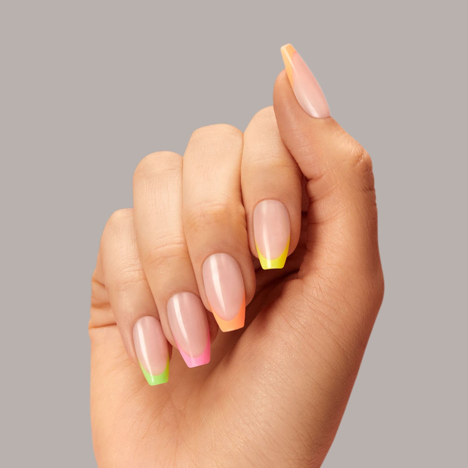 Long length, coffin shape, glossy finish. Sheer nude press-on gel nails featuring multicolor neon french tips.