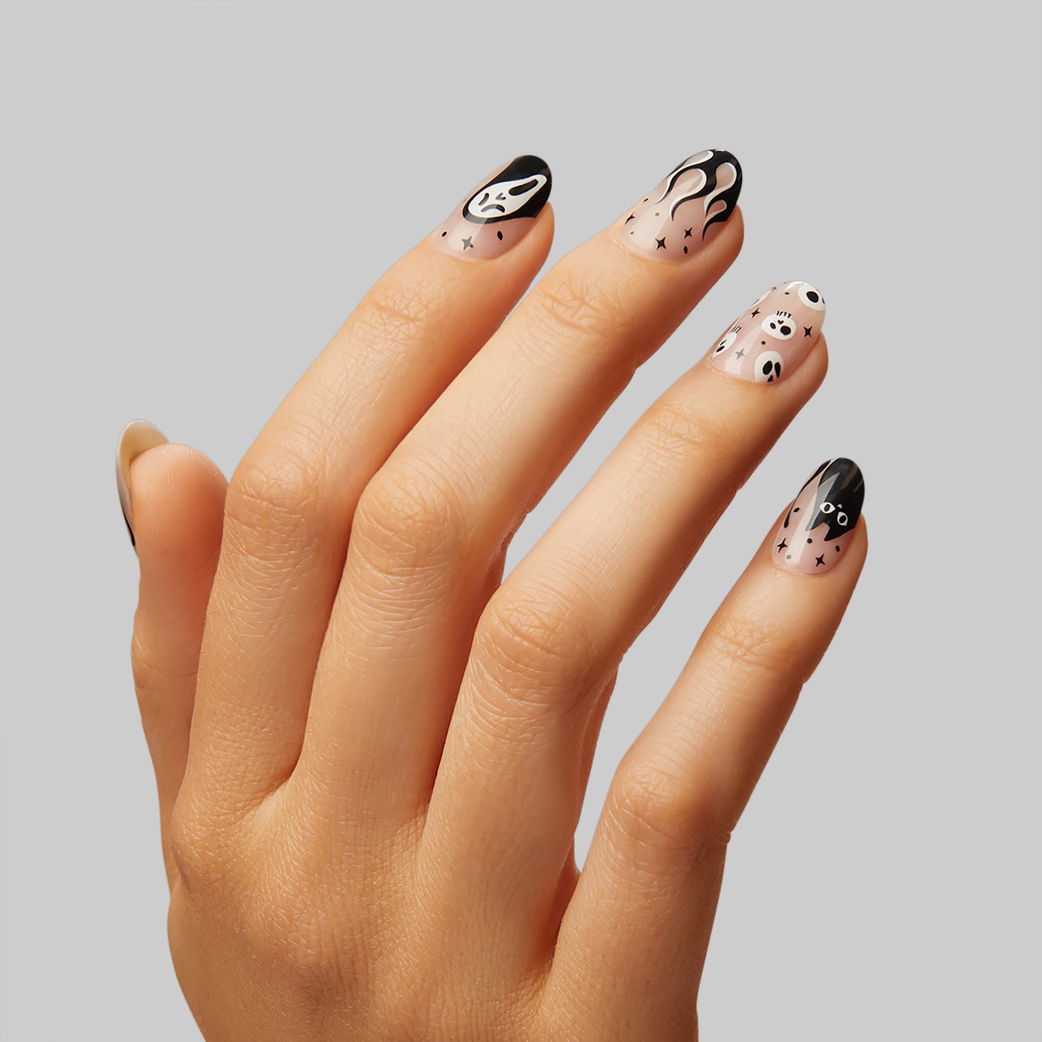  Medium length, almond shape, glossy finish. Sheer nude pink press-on gel nails featuring bats, black cats, and skull icons.