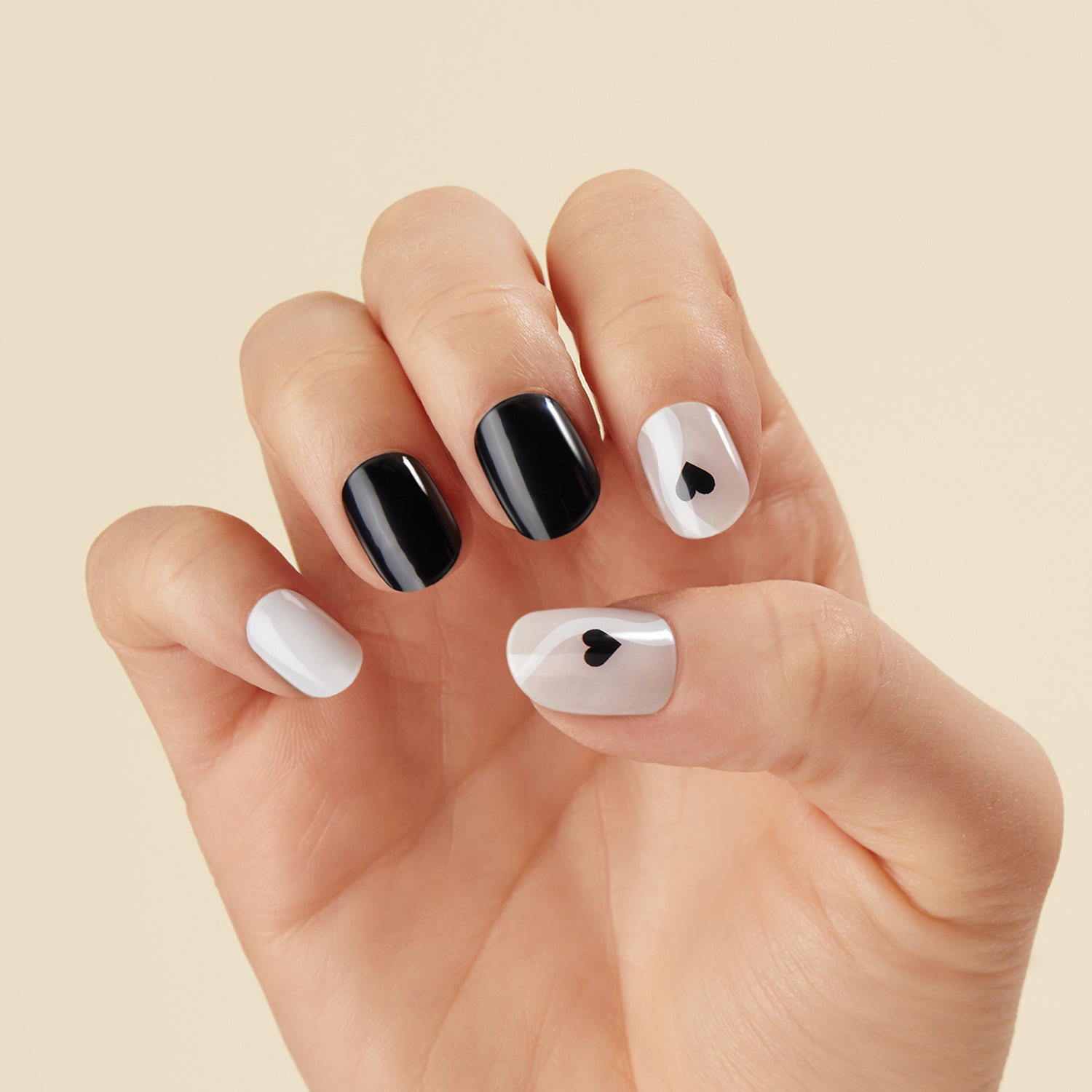 Semi-cured white & sheer nude gel nail strips featuring black hearts and abstract waves with mega volume & maximum shine.