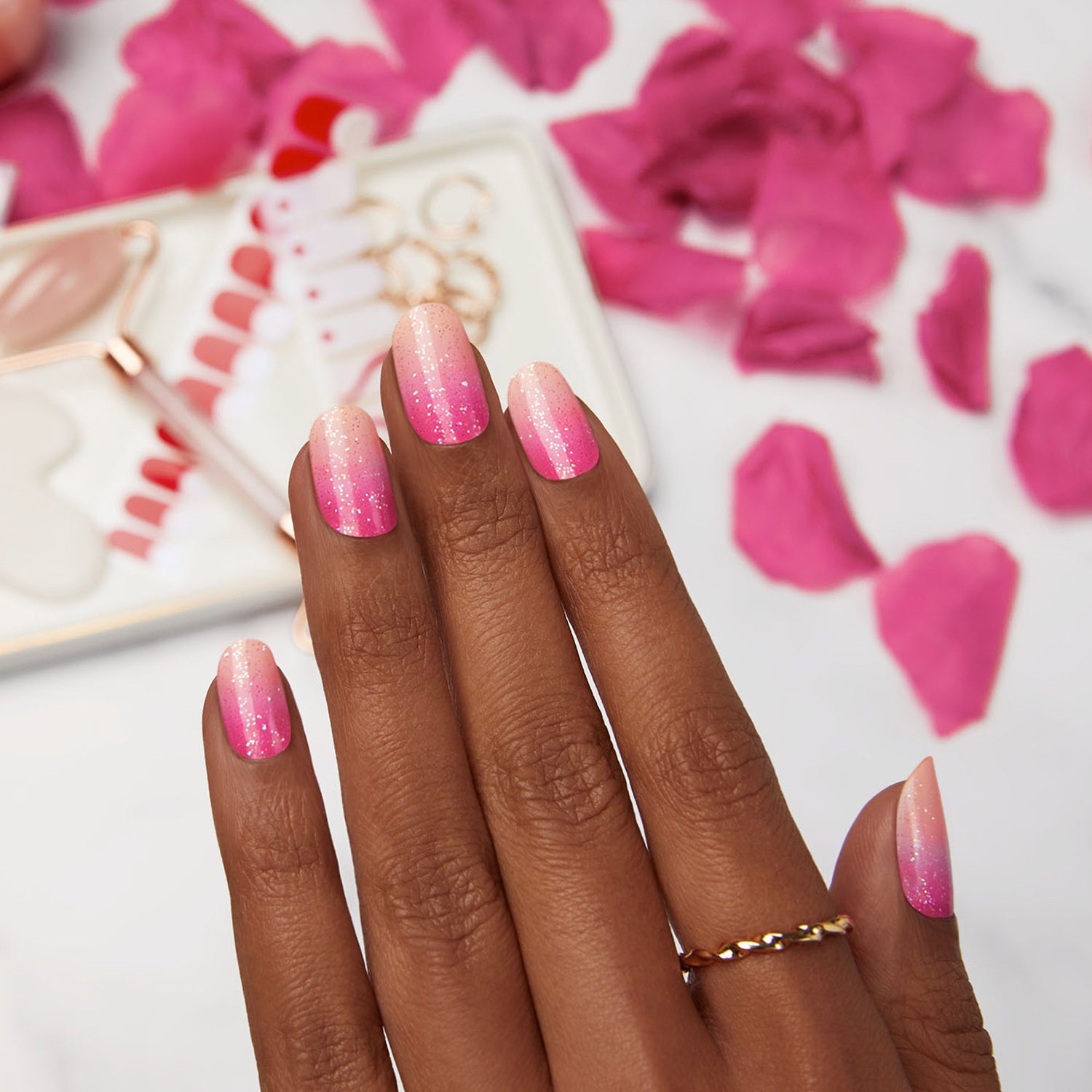  pink nail strips featuring an ombré pink design, and scattered glitter with a glossy, high-shine finish.