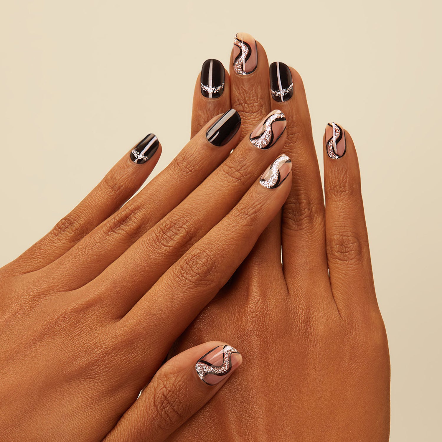 Stark black gel nail strips featuring silver glitter swirl accents 