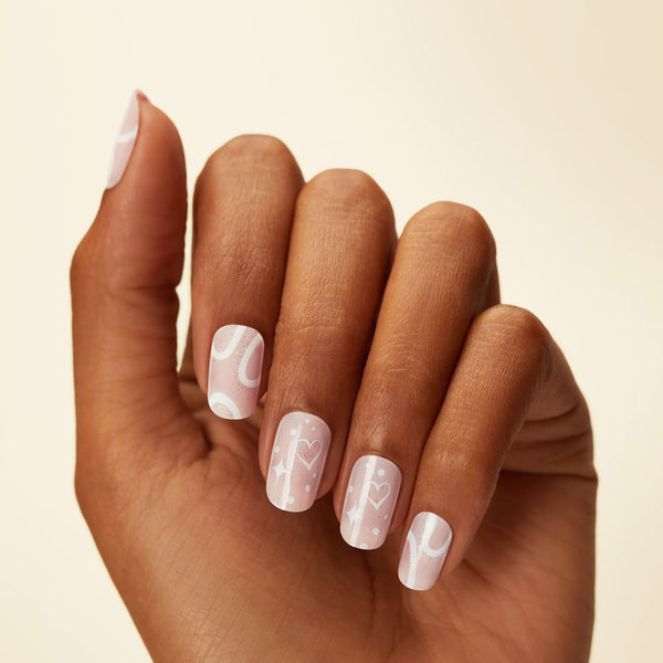 GLOW Nails Strips Sheer nude pink gel nail strips featuring abstract waves, heart accents, and iridescent glitter with a double gel formula for a smooth finish!