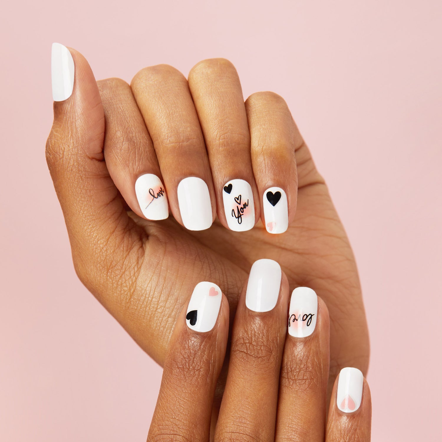 nail art stickers featuring expressive designs, including French tips with black and blush accents, glitter-filled hearts, and love notes.