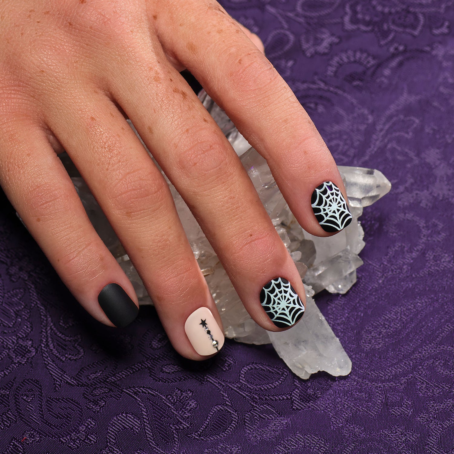 Short length, square shape, glossy & matte black press-on gel nails featuring silver spiderwebs, rhinestones, and line art accents with Glow in the dark details.