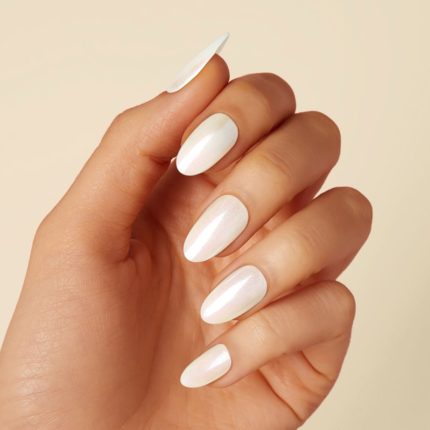 Off-white pearlescent press-on gel nails featuring, medium length, almond shape, and a metallic chrome finish.