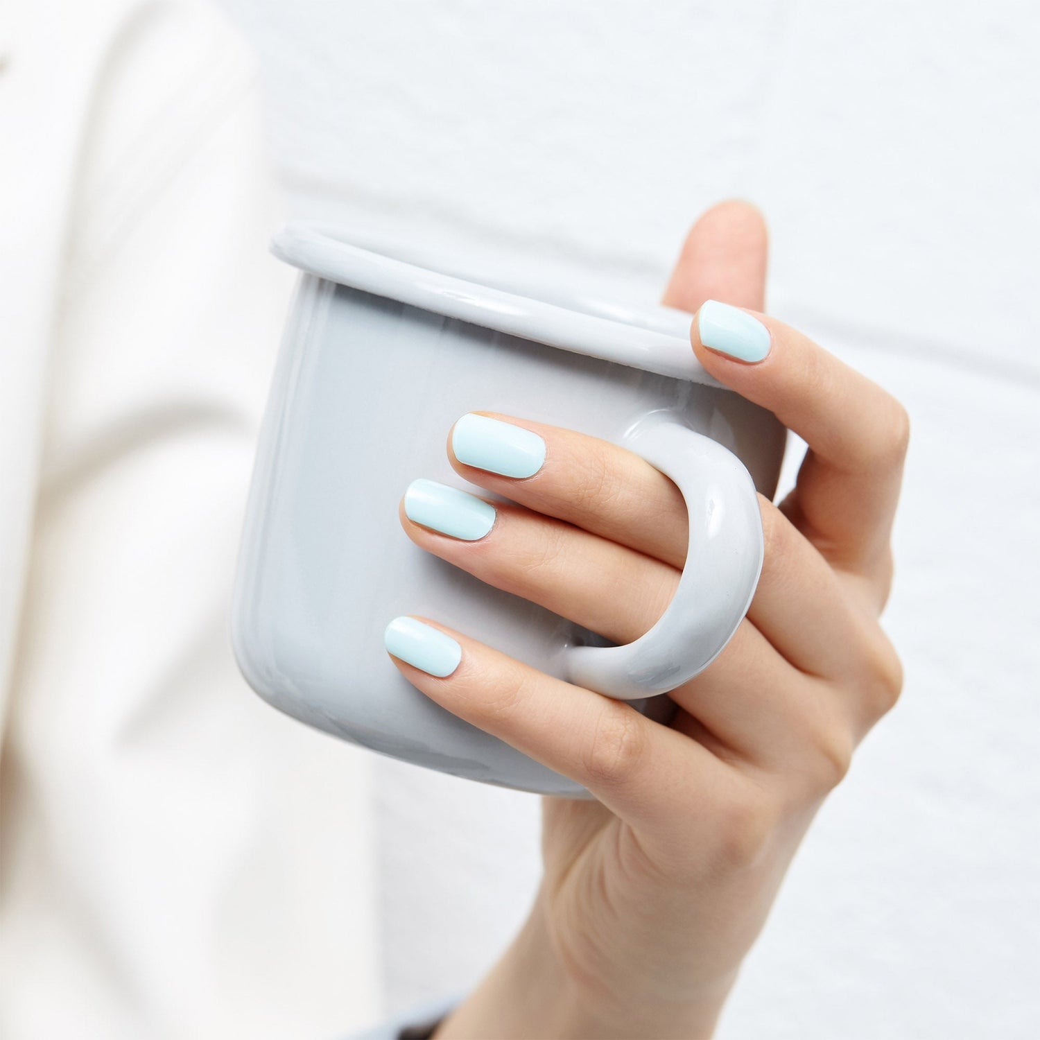 Female Hand With Long Nails And Light Blue Manicure With Bottles Of Nail  Polish Stock Photo, Picture and Royalty Free Image. Image 156232786.